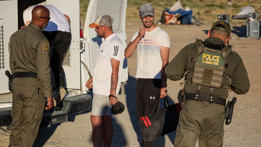 Jacumba Hot Springs, CA, Sunday, May 12, 2024 – A Turkish migrant thanks a Border Patrol agent as he is loaded into a van hours after crossing the border through rocky, mountainous terrain.  (Robert Gauthier/Los Angeles Times via Getty Images)